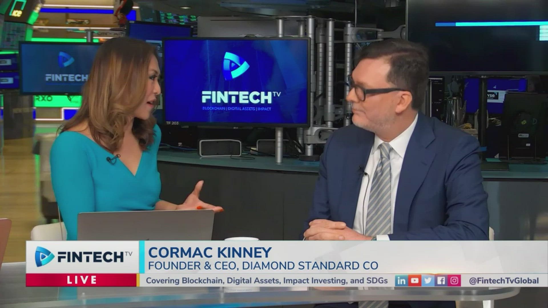 Cormac Kinney of Diamond Standard speaks in a blue-tinted Fintech TV studio, wearing a dark suit and glasses, with a Fintech TV logo backdrop