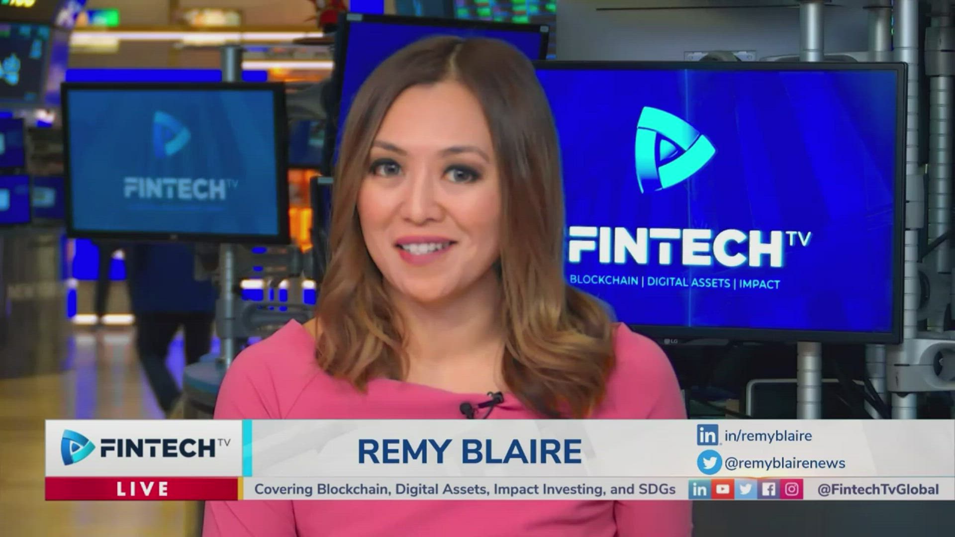 Remy Blaire on FintechTV, wearing a pink top in a studio with blue FintechTV screens in the background, delivering a tech and crypto news segment.