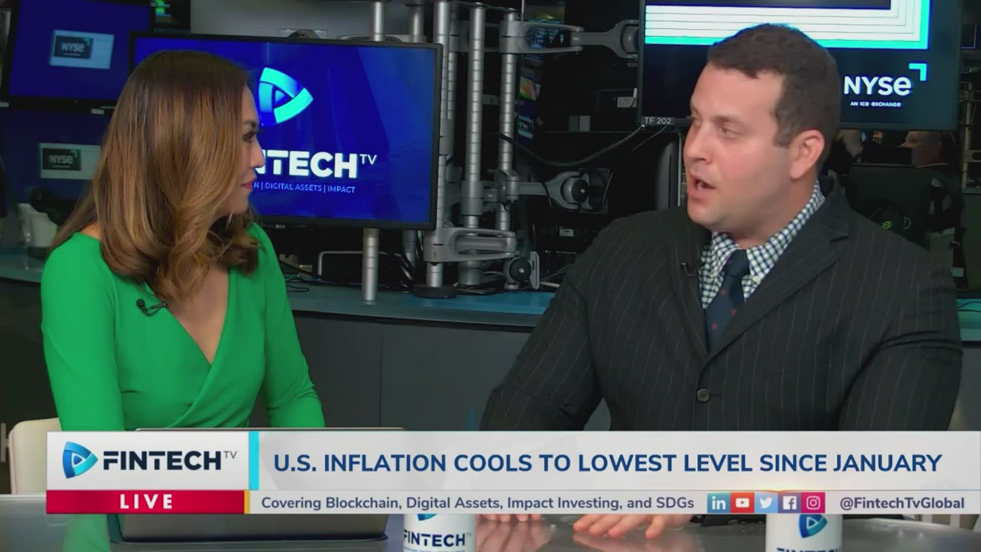 Alexander Fleiss and a female host discuss inflation trends on FINTECH.TV in a modern studio with NYSE screens in the background, blue branding and professional attire.